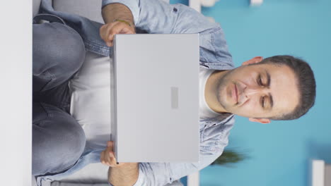 Vertical-video-of-Concentrated-man-working-on-laptop.